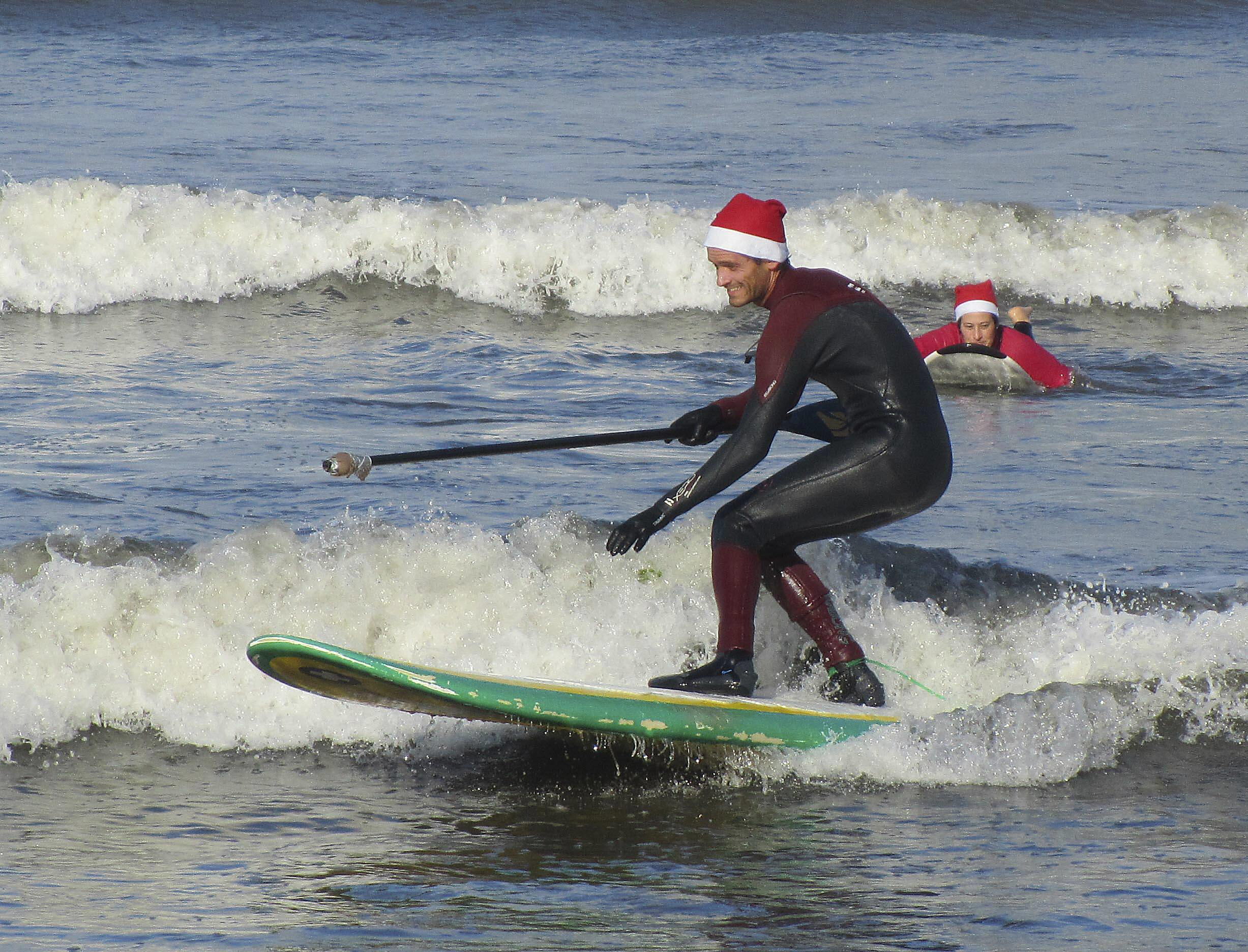 Papá Noel cambia el trineo por la tabla de surf en la playa de Ladeira