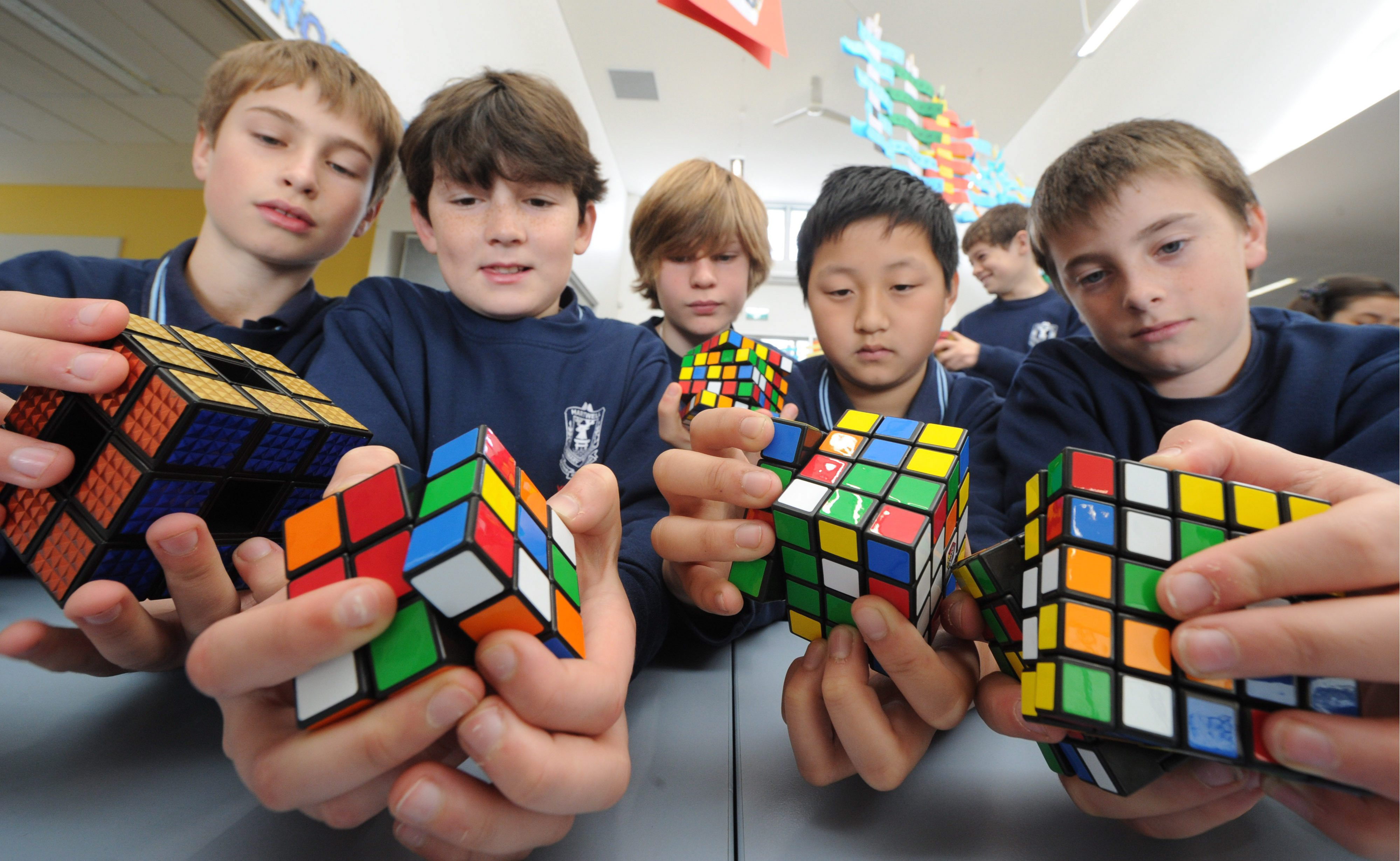 Блогеры кубики. Ребенок с кубиком Рубика. Кубик рубик школа. Человек собирает кубик Рубика. Собрать кубик Рубика.