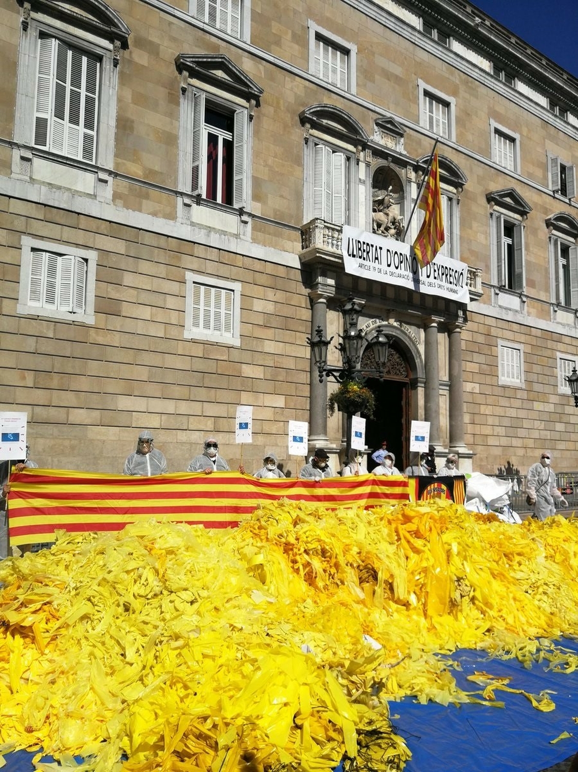 Activistas antiindependentistas vuelcan sacos de lazos amarillos frente a la Generalitat